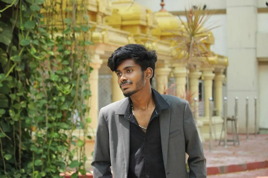 Baskar in a grey blazer, standing outside a temple in Chennai